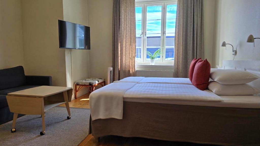 Rymligt familjerum på Hotel Emma med flera bäddar och sittgrupp